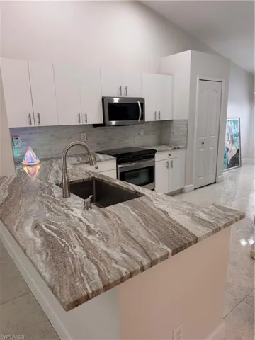 Kitchen island featuring a single-basin sink with a gooseneck faucet
