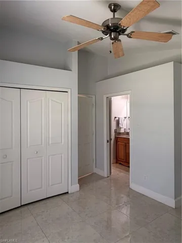 Bedroom #2 looking into full bath. Large format tile flooring throughout