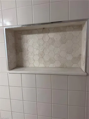 Recessed shower niche with hexagonal tile backing and integrated shelving