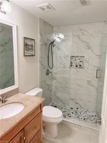 Cccess to this bathroom from hall for guest and to bedroom #2 Walk-in shower with clear glass enclosure and stone-look subway tile surround