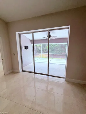 Sliding glass doors opening to a screened lanai with a ceiling fan