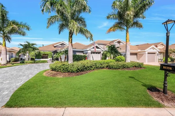 View of front facade featuring a garage and a front lawn