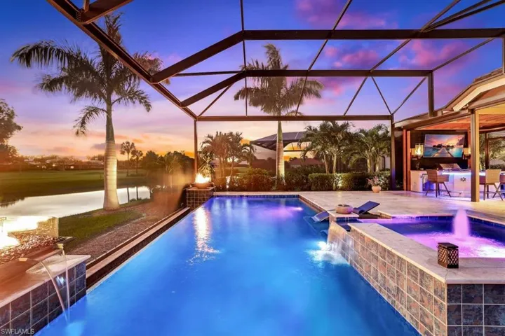 Pool at dusk featuring pool water feature, a patio, and a lanai