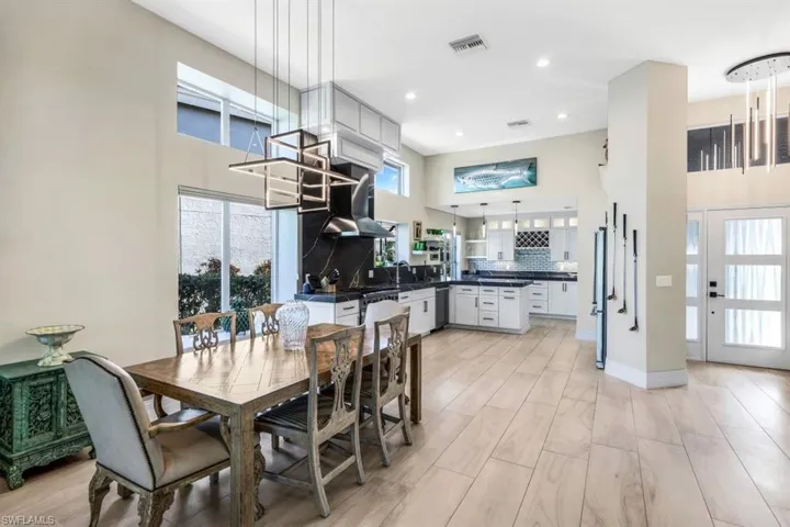 Dining area with a towering ceiling, sink, and light hardwood / wood-style floors
