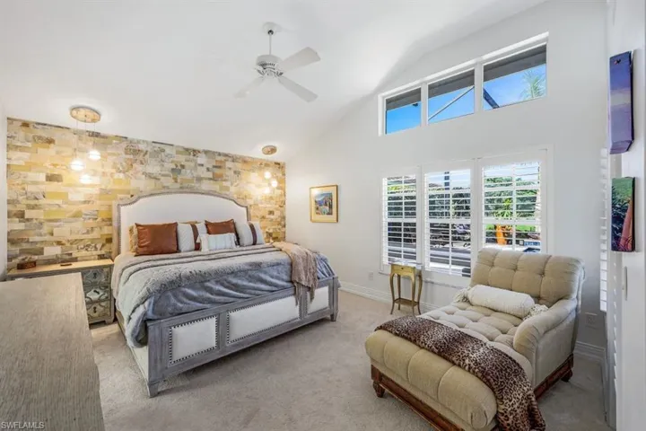 Carpeted bedroom featuring lofted ceiling and ceiling fan