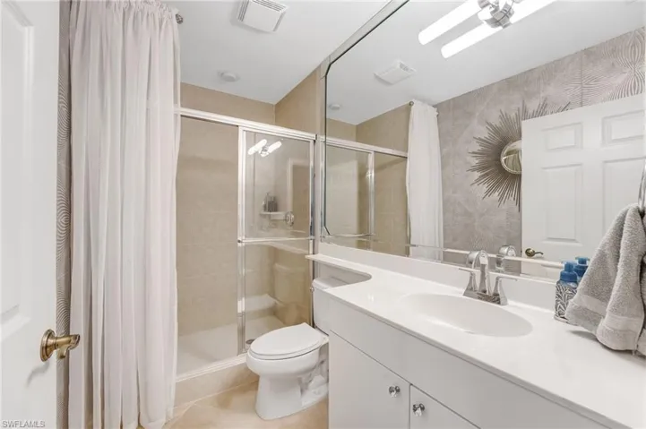 The third full bath, conveniently located across from the second bedroom, features a walk-in shower.
