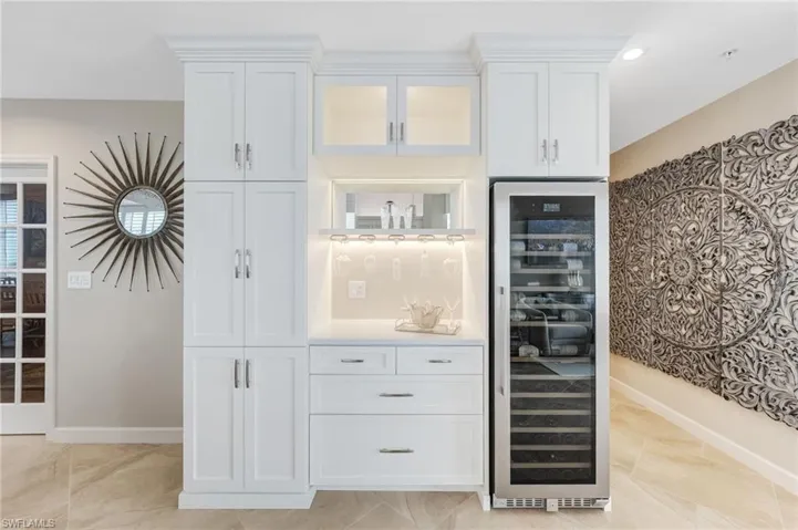 A spectacular built-in bar features a 150-bottle wine cellar, illuminated glass-front cabinetry, and abundant storage.