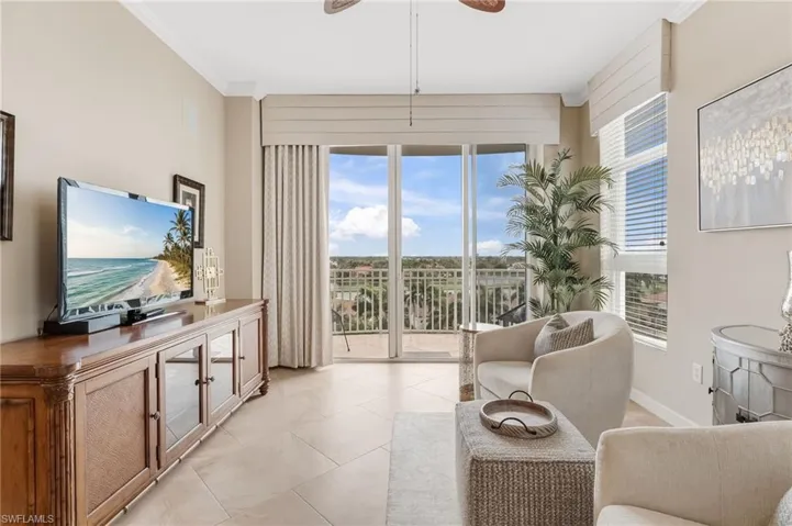 The sun-drenched sitting room is wonderfully versatile—ideal as a breakfast nook, play area, or sewing room—flooded with natural light, offering stunning views of downtown Fort Myers, the golf course, and shimmering lakes, all complemented by custom window coverings.