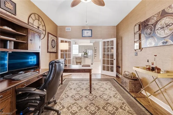 A stunning office features French glass doors for added privacy and beautiful luxury vinyl flooring.