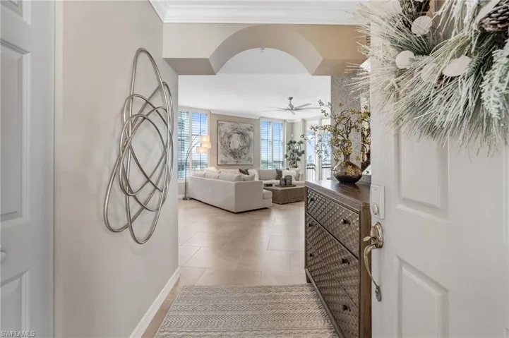 A graceful arched entry adorned with stunning wallpaper warmly invites you into this exceptional condo.