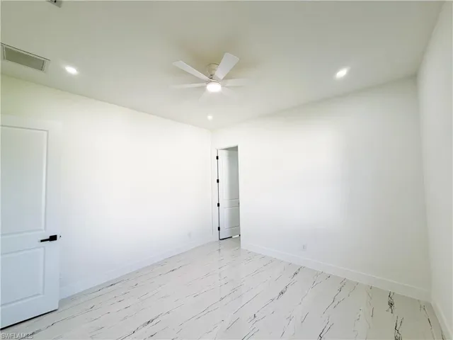 Bright interior space featuring large format white tile flooring with dark veining