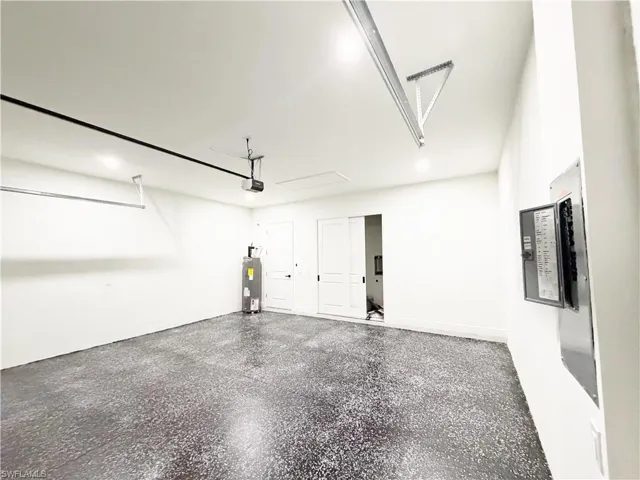 Spacious garage featuring a durable speckled epoxy floor, white painted walls, recessed lighting, and a garage door opener system