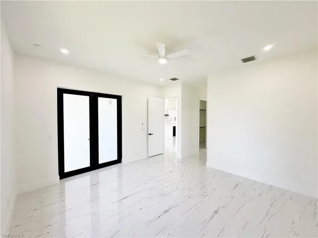 Spacious interior featuring white walls and large format porcelain tile flooring