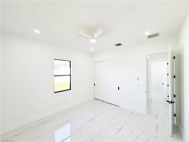Spacious room featuring white porcelain tile flooring, a contemporary ceiling fan, and recessed lighting