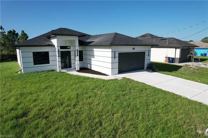 Modern white stucco exterior featuring a dark asphalt shingle roof, a two-car garage with a dark door, and a concrete driveway