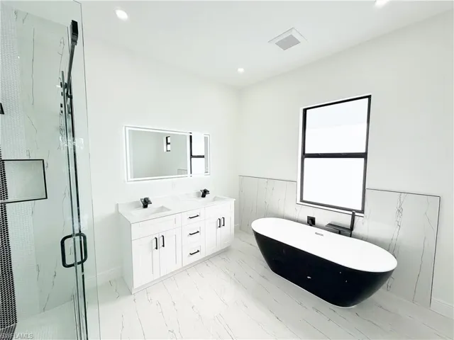 Freestanding black and white soaking tub with a large window