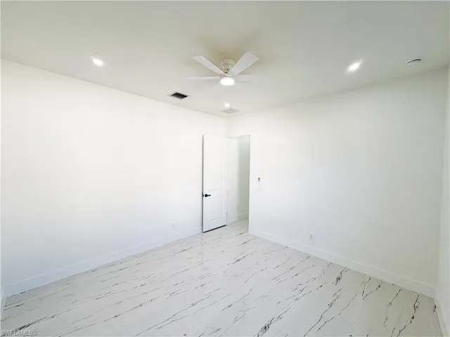 Bright interior space featuring large format marble-look tile flooring, white walls, and recessed lighting