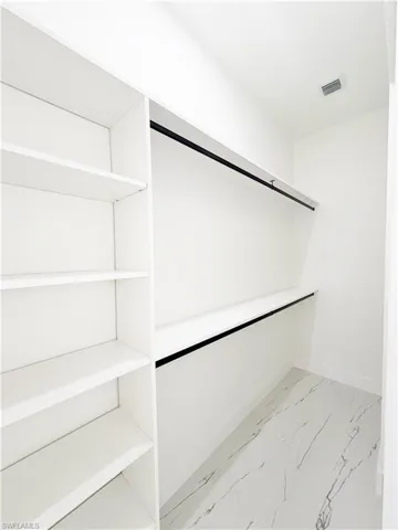Custom closet system featuring white shelving and hanging rods