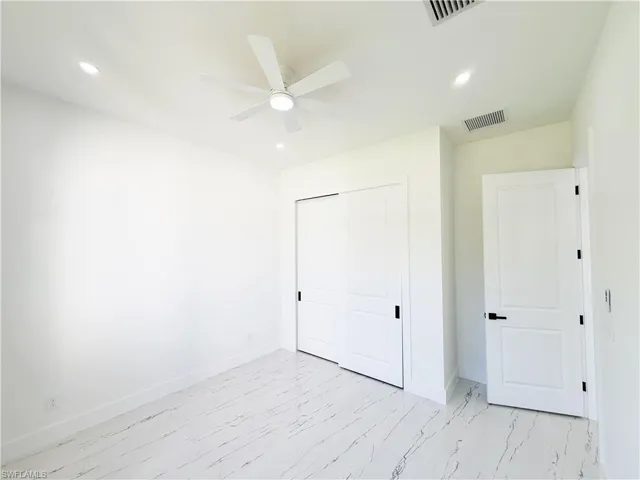 White tile flooring with dark veining, recessed lighting, and a ceiling fan