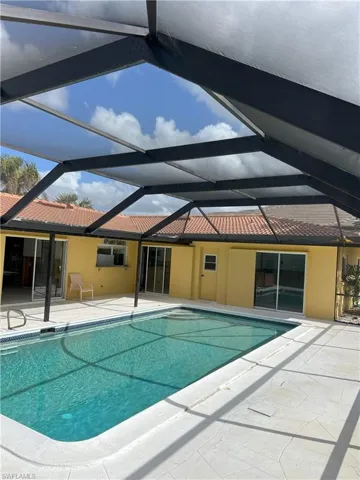 View of pool with a patio and a lanai