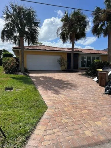 Single story home with a front lawn and a garage