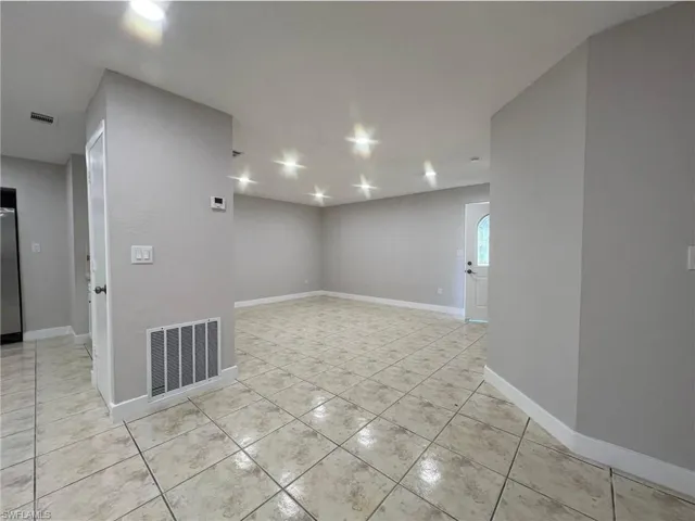 Unfurnished room featuring baseboards and light tile patterned flooring