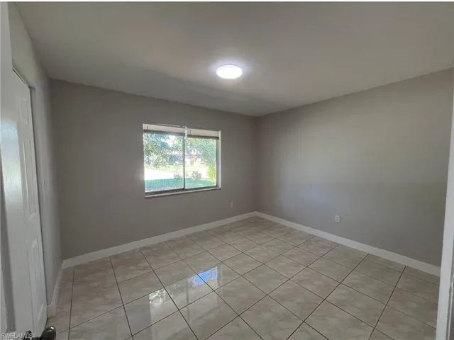 Unfurnished room with baseboards and light tile patterned floors