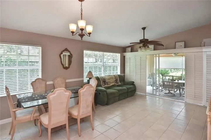 Tiled flooring extends throughout, complemented by a contemporary ceiling fan and a multi-light chandelier