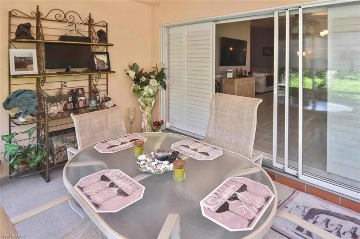 Screened patio with a tile floor, white louvered shutters, and large sliding glass doors
