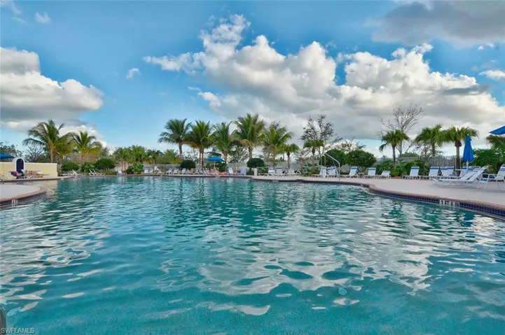 Expansive swimming pool with a curved design, bordered by a textured deck