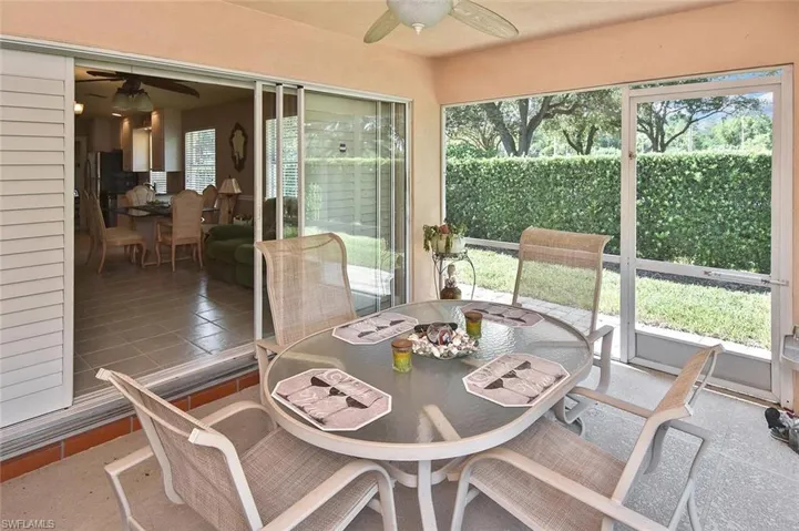 Screened patio with a tiled floor, overhead ceiling fan, and sliding glass doors