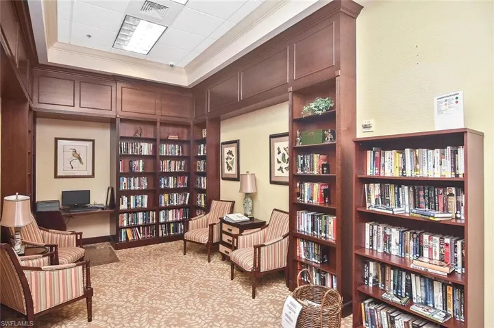 Recessed lighting, wood-finish built-in shelving, desk area, patterned carpet, and decorative wall art