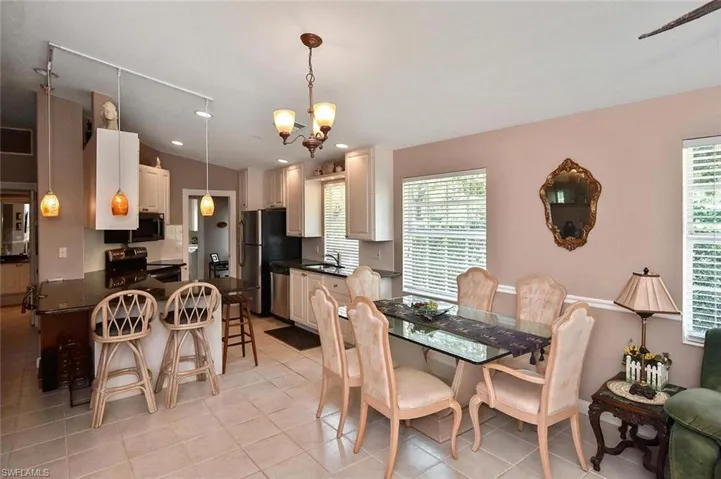 Tiled flooring, pendant lighting, built-in cabinetry, stainless steel appliances, and a chandelier