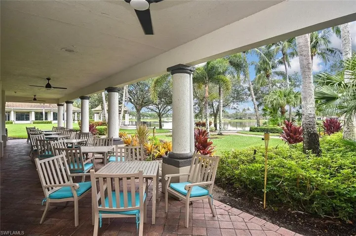 Covered patio with brick paver flooring, multiple ceiling fans, and structural columns