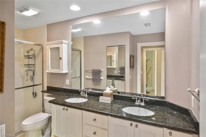 Dual vanity with undermount sinks, stone countertops, and integrated mirror
