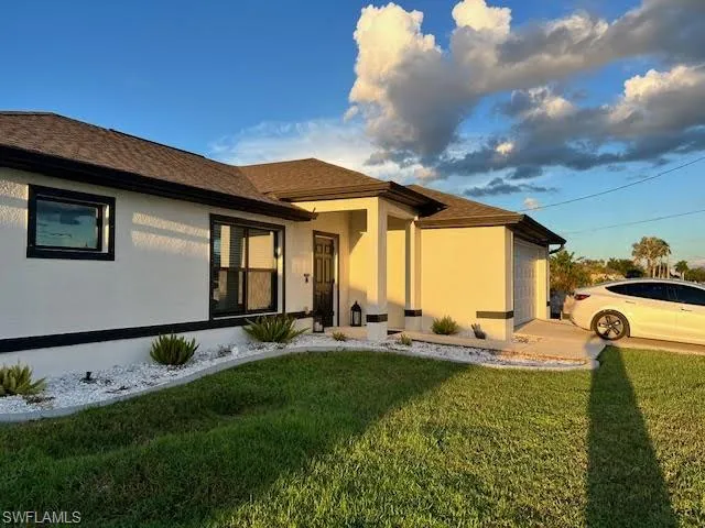 Back of property featuring a yard
