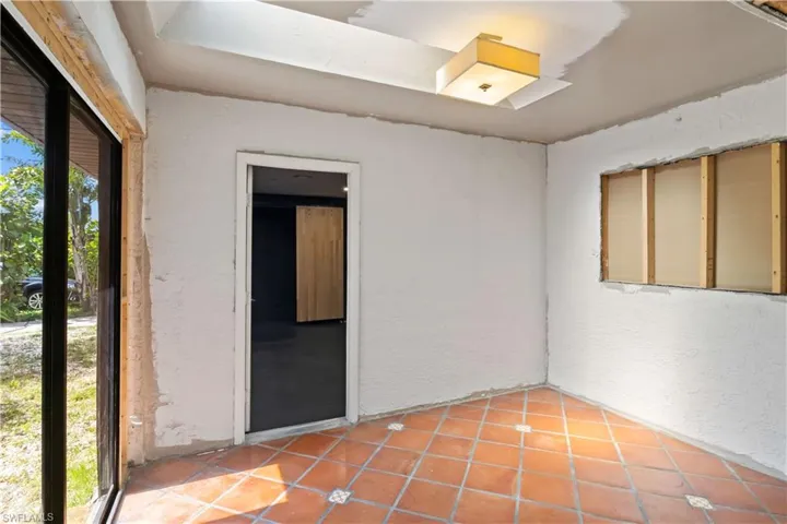 Spare room with a textured wall and light tile patterned flooring