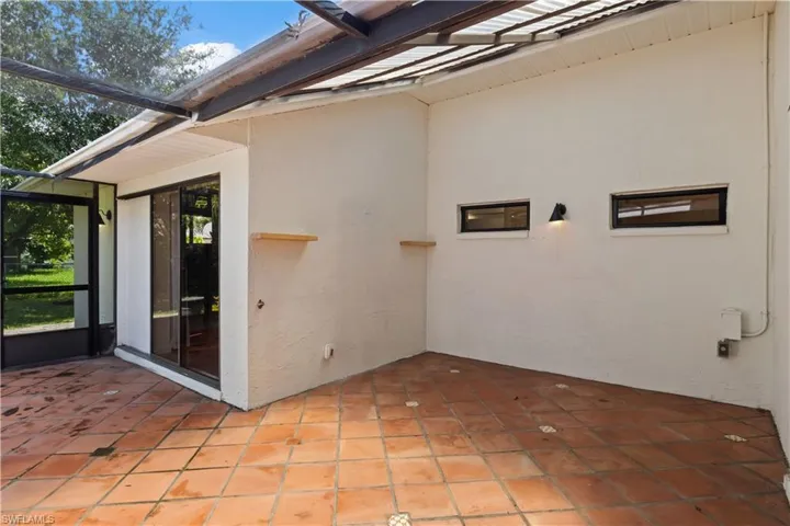 View of patio featuring a lanai