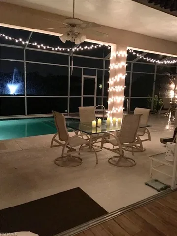 View of pool with a lanai and ceiling fan