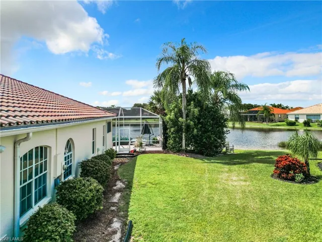 View of yard with a lanai and a water view