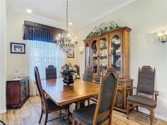 Dining room featuring crown molding, a chandelier, and light hardwood / wood-style flooring