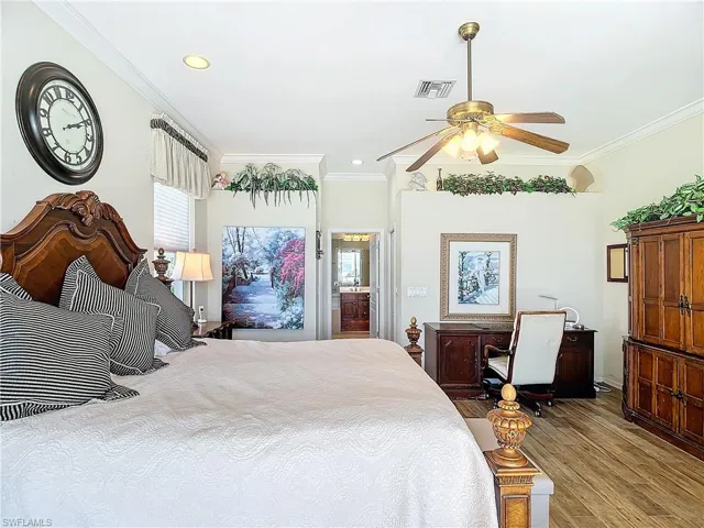 Bedroom with ceiling fan, ornamental molding, and light hardwood / wood-style floors