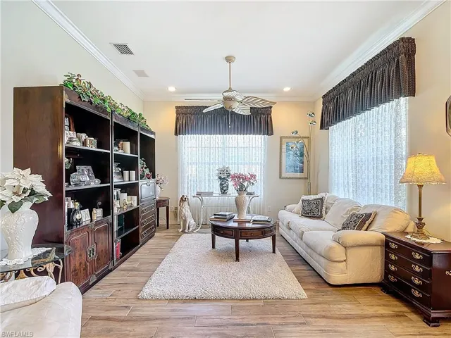 Living room featuring ornamental molding, light hardwood / wood-style floors, ceiling fan, and plenty of natural light