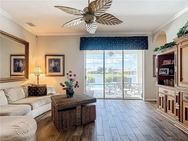 Living room with ceiling fan, crown molding, and dark hardwood / wood-style flooring