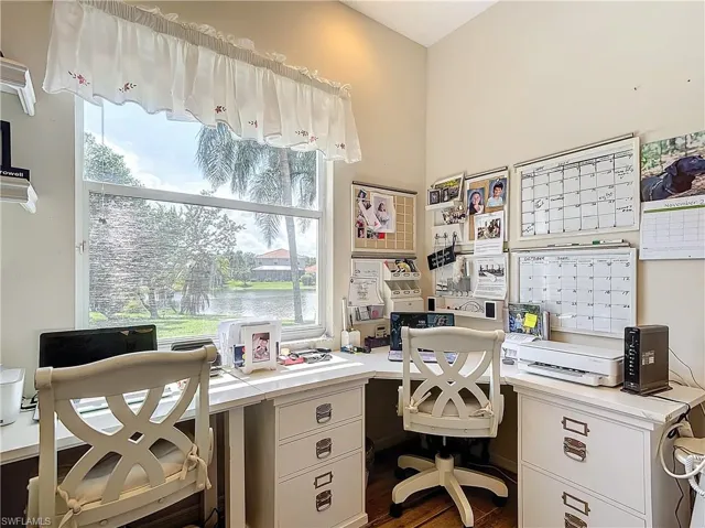 Home office featuring plenty of natural light and dark hardwood / wood-style flooring