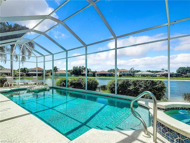 View of swimming pool with a water view, glass enclosure, an in ground hot tub, and a patio area