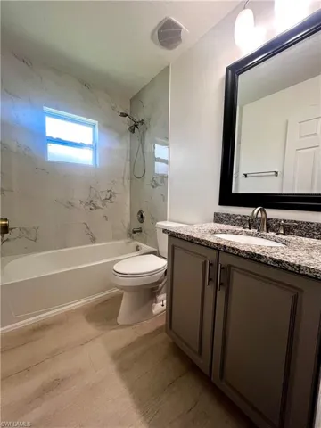 Full bathroom featuring tub / shower combination, vanity, and wood finished floors
