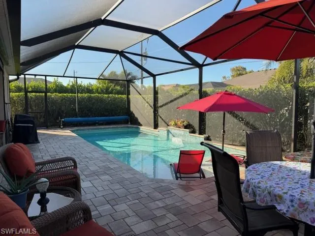 Custom designed pool included with a tranquil water feature, a patio area, screen enclosure with easy to maintain landscape for added privacy.