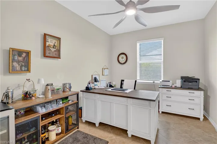 Office area with a ceiling fan, beverage cooler, and light tile patterned floors
