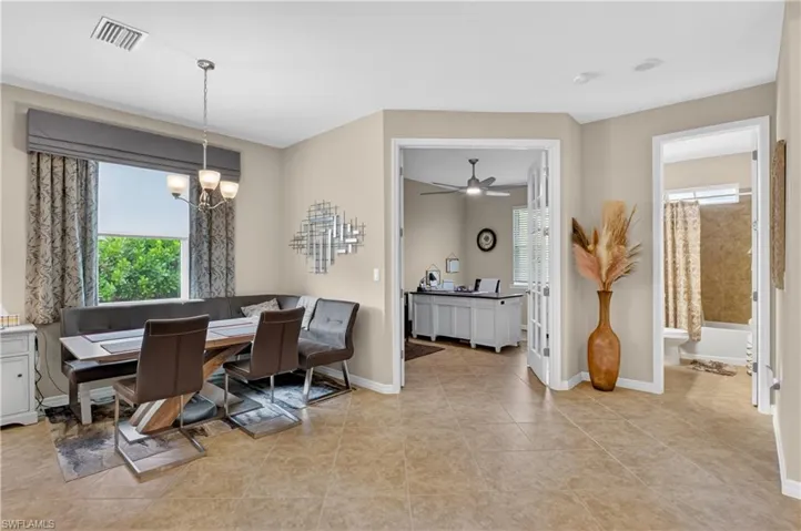 Dining area with a chandelier, a ceiling fan, and light tile patterned floors